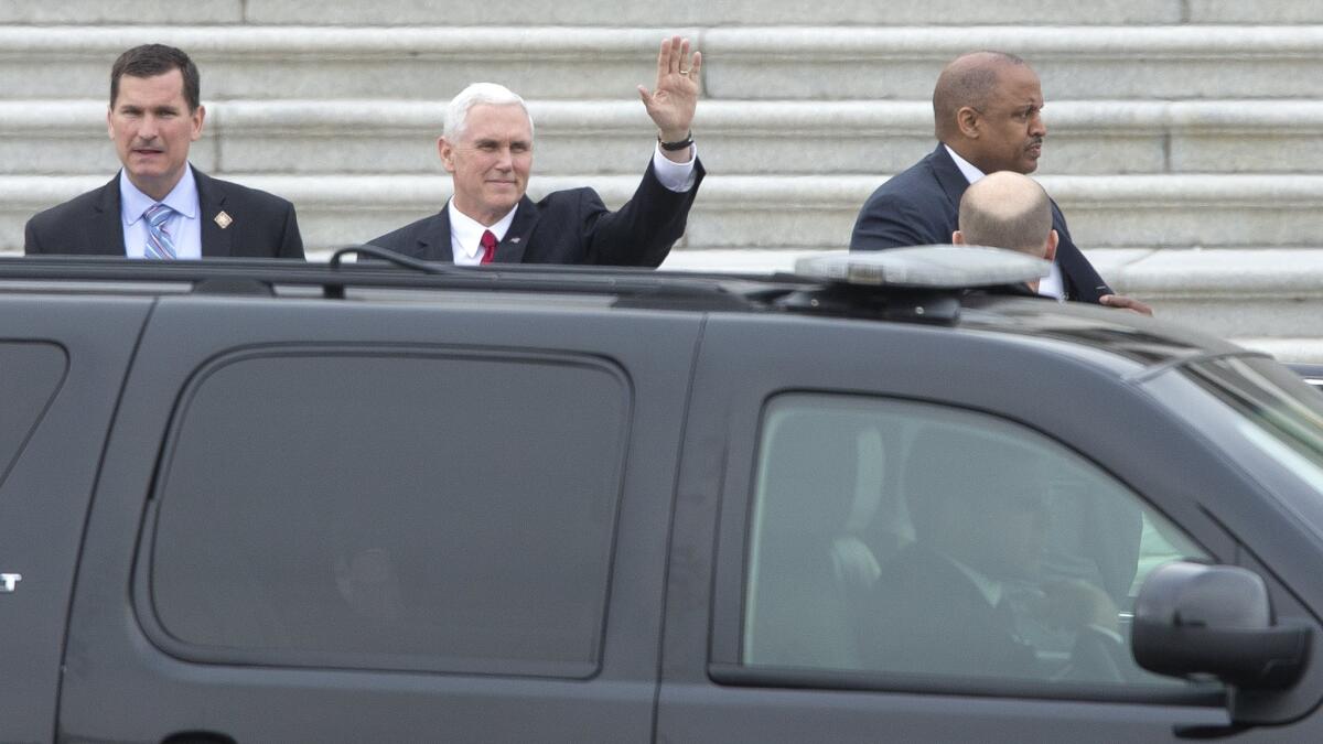 Vice President Mike Pence waves as he enters his motorcade on Capitol Hill.