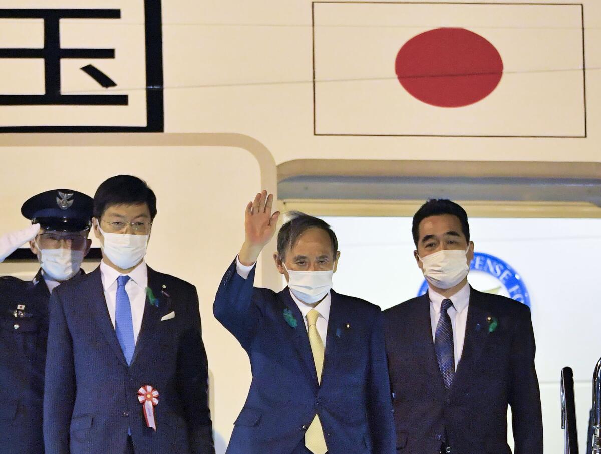 Japanese Prime Minister Yoshihide Suga waves