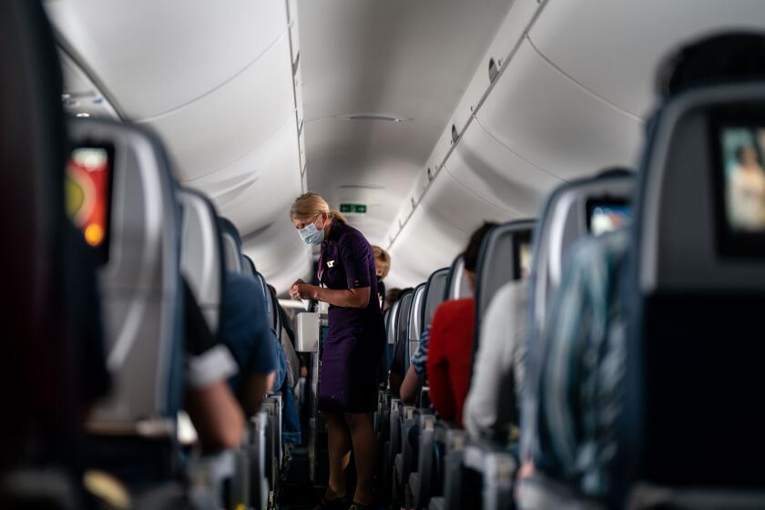 ARLINGTON, VA - MAY 21: Flight attendants hand out refreshments to a packed Delta Airlines flight traveling from Ronald Regan National Airport to Minneapolis−Saint Paul International Airport on Friday, May 21, 2021. (Kent Nishimura / Los Angeles Times)