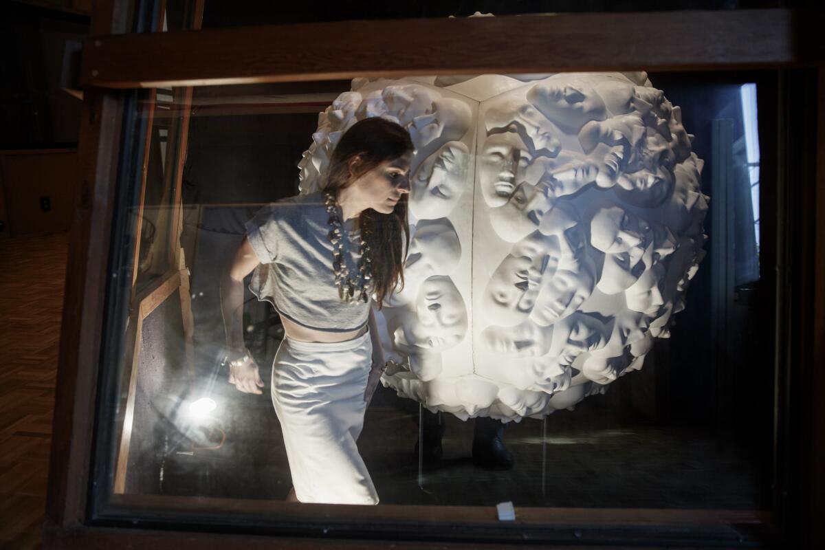 Curator Ashley Sands walks past Tamara Kvesitadze's "Sphere, 2011," staged inside a drum recording booth in Frank Zappa's L.A. studio. It's part of an appointment-only exhibition titled "Someplace Else Right Now."