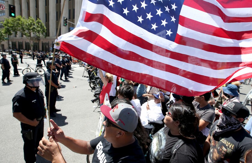 Anti-Trump protesters yell across the street at supporters as separate May Day marches and rallies converge at 1st and Spring streets in downtown Los Angeles.