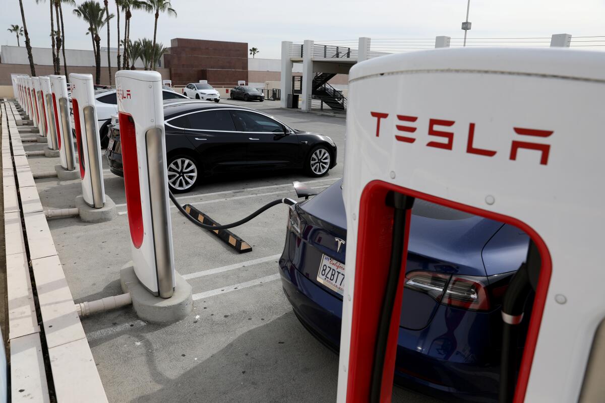 Tesla vehicles plugged in at a Supercharger station