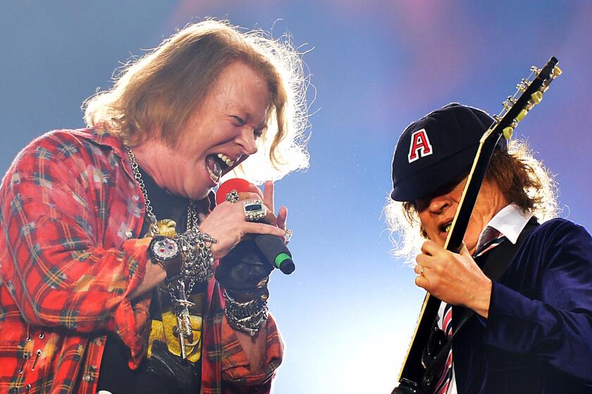Axl Rose, left, and Angus Young perform at Olympic Stadium in London on June 4.