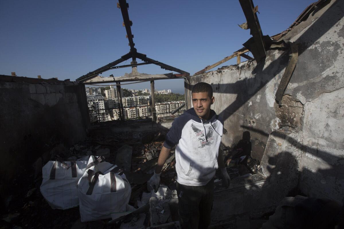 An Israeli inspects his burned house after a major fire swept the northern coastal city of Haifa.