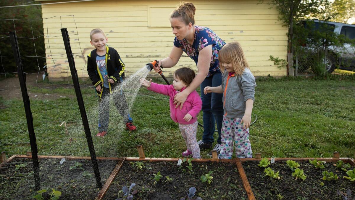 Clarisa Corber and her children in their garden. Last year, the family finances were sometimes so stretched that they relied on help from Clarisa’s church to get food.