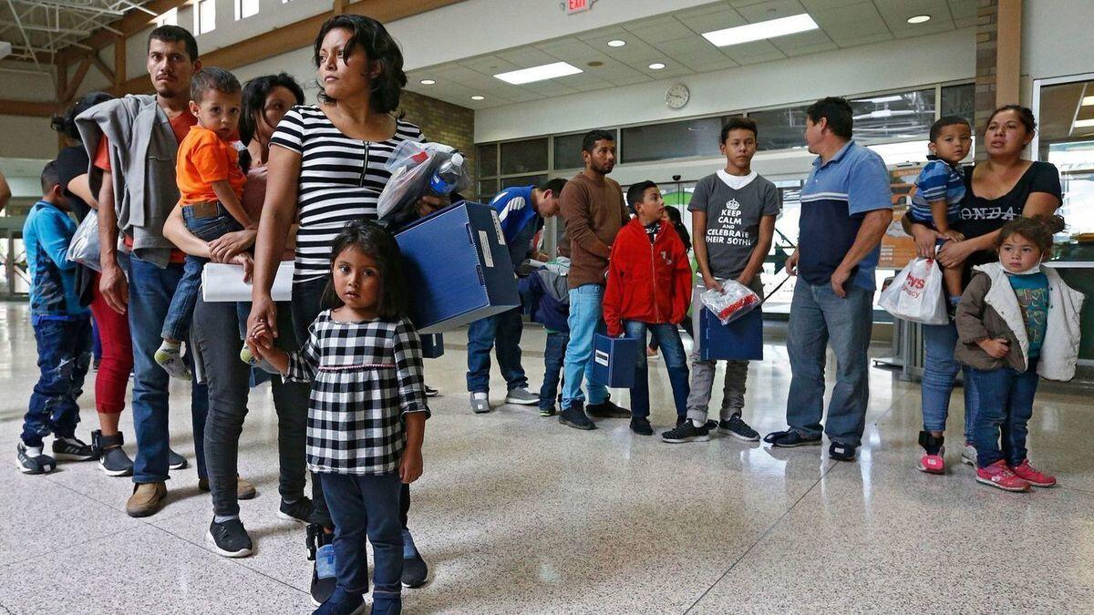 Migrant families wait for immigration processing at a bus station in McAllen, Texas.