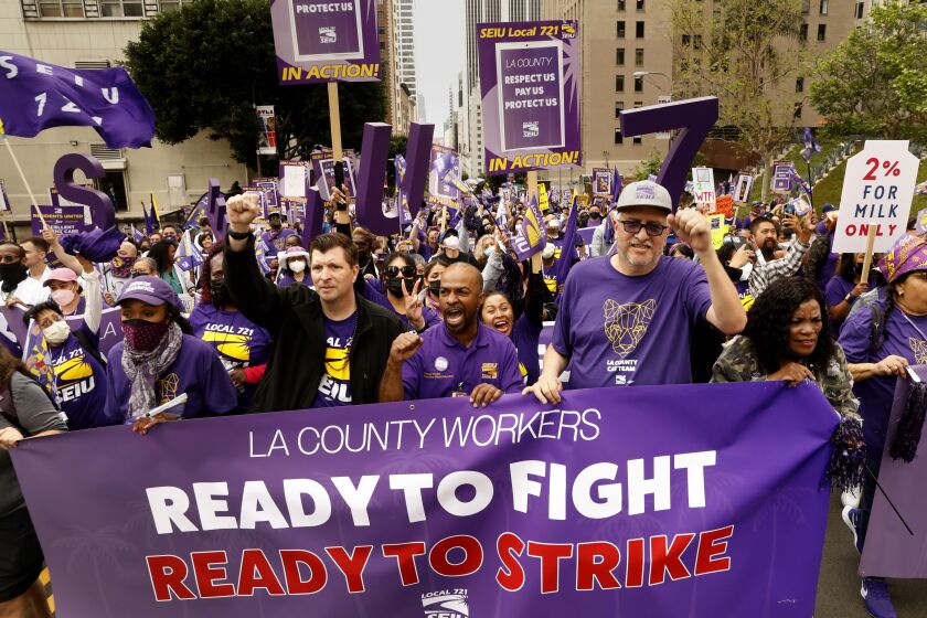 Los Angeles, California-March 31, 2022- -SEIU Local 720 President David Green, second from left in blazer, and other leaders take part in a SEIU Local 721 rally. About 5,000 workers from the SEIU Local 721 rally at the Kenneth Hall of Administration Building in downtown Los Angeles on March 31, 2022. SEIU stands for Service Employees International Union. A six-month long short-term contract between SEIU Local 720 and Los Angeles County is set to expire Thursday at midnight. After that point, SEIU members will discuss options, including a potential strike, which will be needed to be voted on by the roughly 55,000 members. The employees work all over the county and represent departments such as Los Angeles County-USC Medical Center, Los Angeles County Department of Public Social Services, Los Angeles County Department of Children and Family Services.(Carolyn Cole / Los Angeles Times)