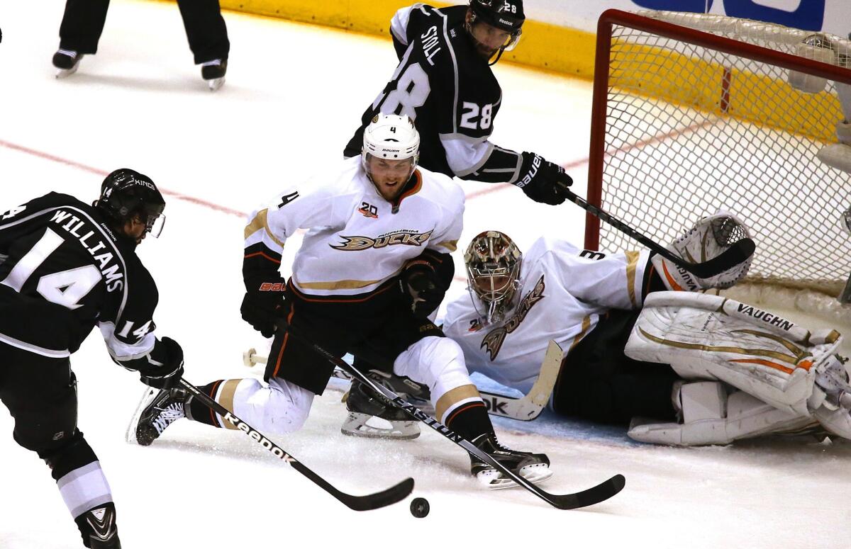 Kings right wing Justin Williams takes a shot against Ducks defenseman Cam Fowler and goalie John Gibson as teammate Jarret Stoll positions himself next at the crease in the second period.