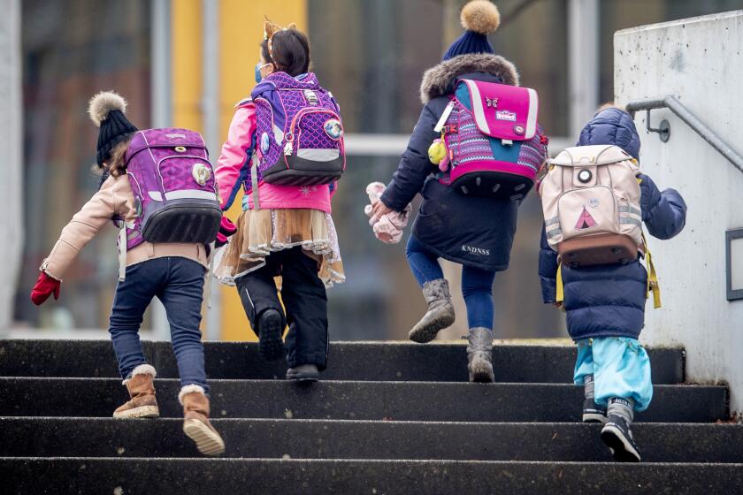 FILE - In this Feb.16, 2021 file photo,Pupils go to school in Frankfurt, Germany. Amid pressure to relax the lockdown, Germany agreed last month to gradually begin reopening schools. Then coronavirus cases started climbing again, prompting authorities in some regions to put those plans on hold even as others press on and insist that in-class teaching needs to be the norm. (AP Photo/Michael Probst,file)