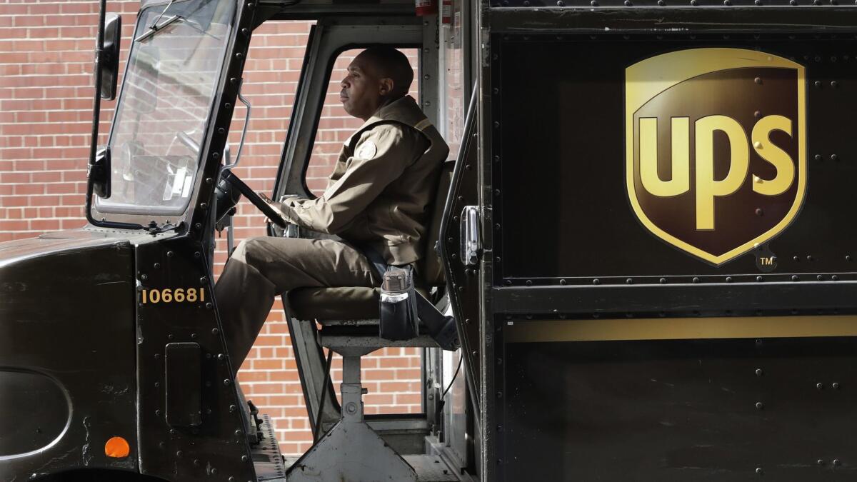 A UPS driver takes his truck on a delivery route in in 2017.