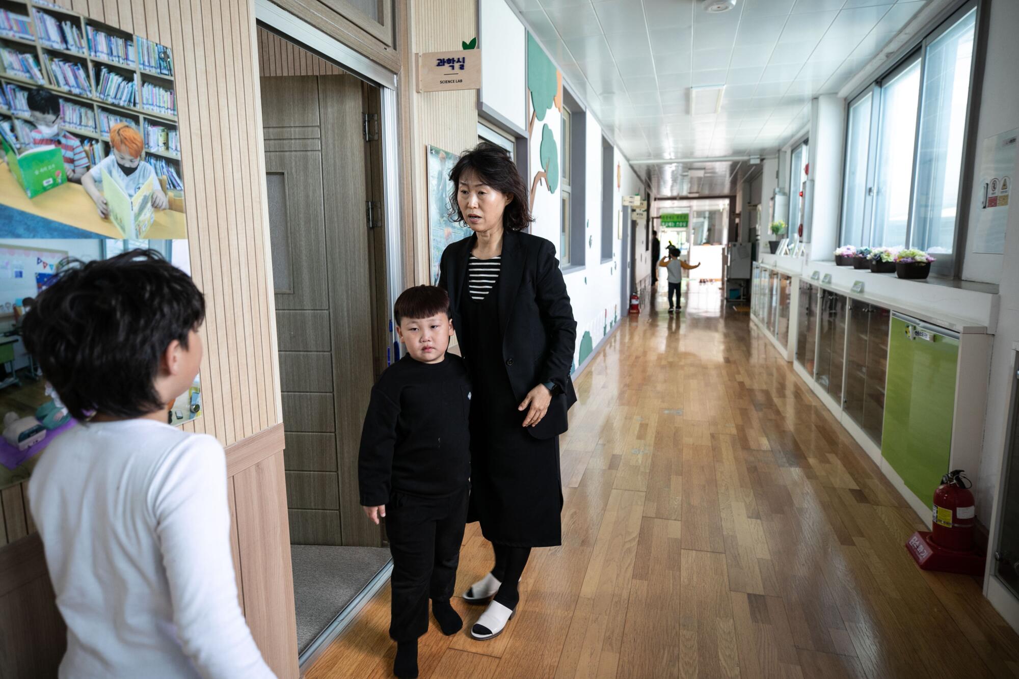 The principal at Dochang Elementary takes a boy back to the classroom.