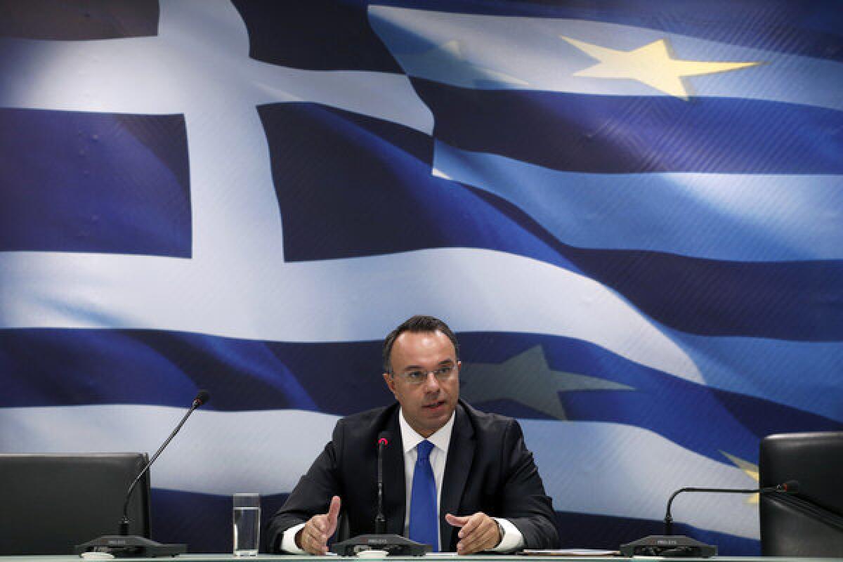 Deputy Finance Minister Christos Staikouras holds a news conference in Athens. He said that the Greek economy is projected to expand 0.6% after a 4% contraction this year.