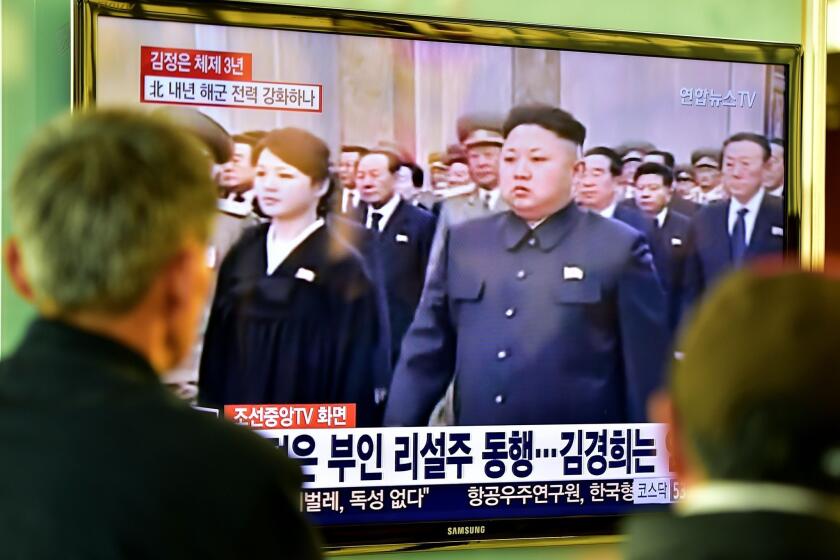 People at a railway station in Seoul watch TV images of North Korean leader Kim Jong Un attending a Dec. 17 ceremony marking the third anniversary of late leader Kim Jong Il's death.