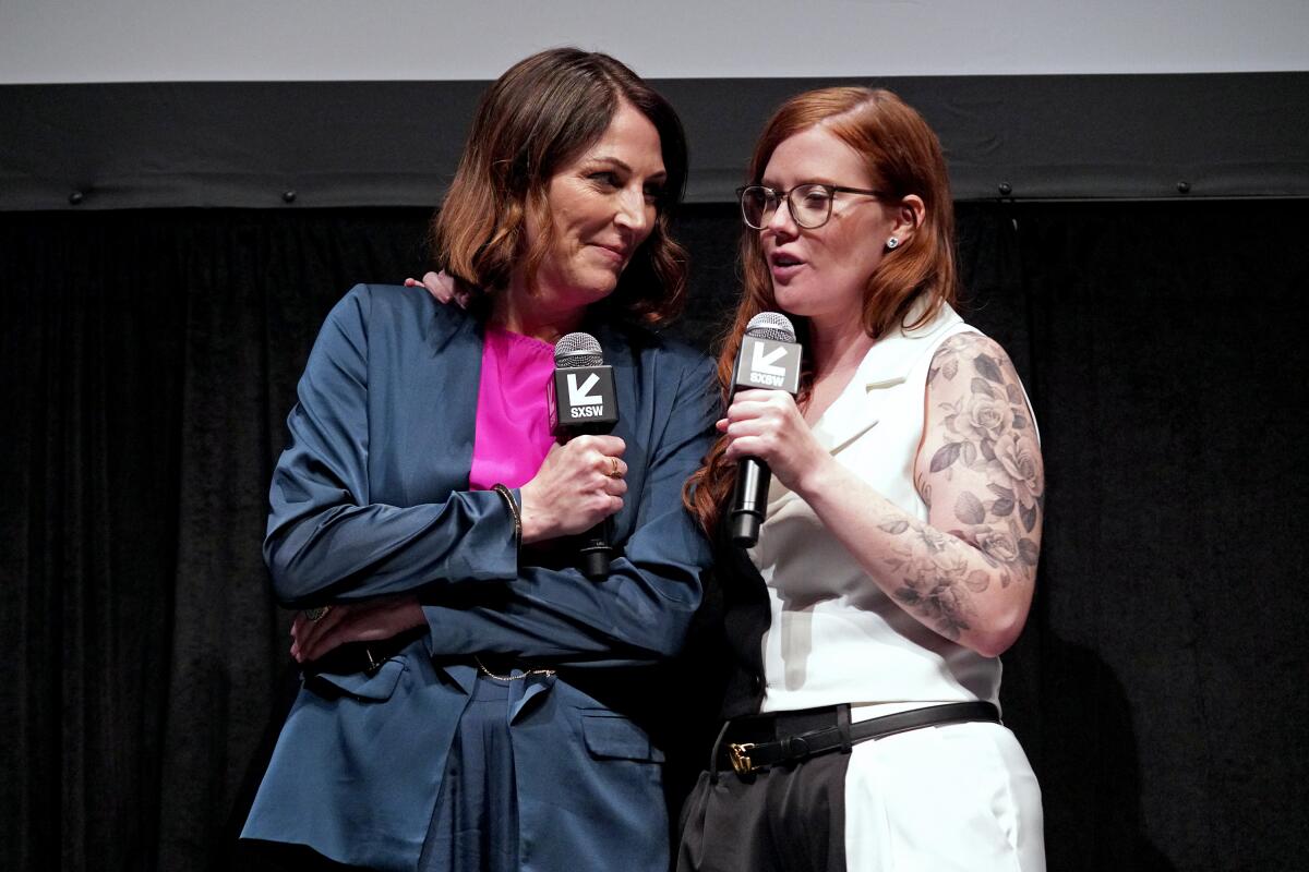 Two women speak into microphones at a film screening.