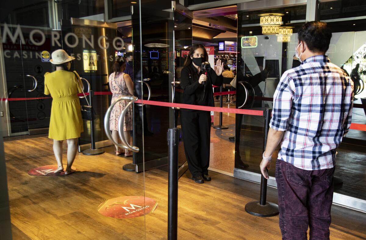 Patrons get their temperatures taken upon entering Morongo Casino which is reopening for the first time since closing on March 17 because of the coronavirus pandemic.