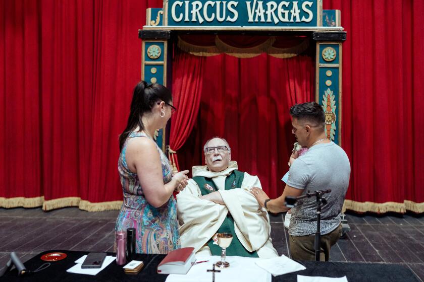 SACRAMENTO, CA - SEPTEMBER 8, 2024. Father Frank Cancro speaks with Daniel Eguino, and his wife, Thatiana Fischer after church Sunday Service held at Circus Vargas on Sunday, September 8, 2024 in Sacramento, CA. (Andri Tambunan / For The Times)