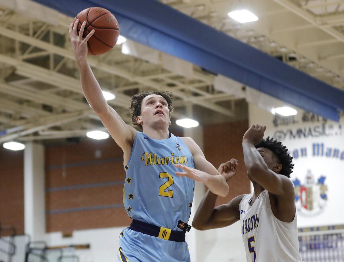 Marina's Eric Hodgkins (2) drives to the basket during a Wave League basketball game against Fountain Valley.