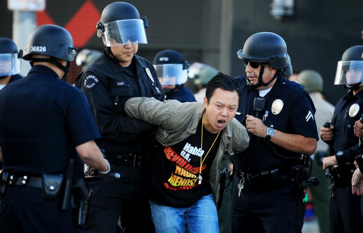 LAPD officers arrest one of about a dozen civil rights protesters blocking the intersection of Washington Boulevard and Main Street in downtown Los Angeles.