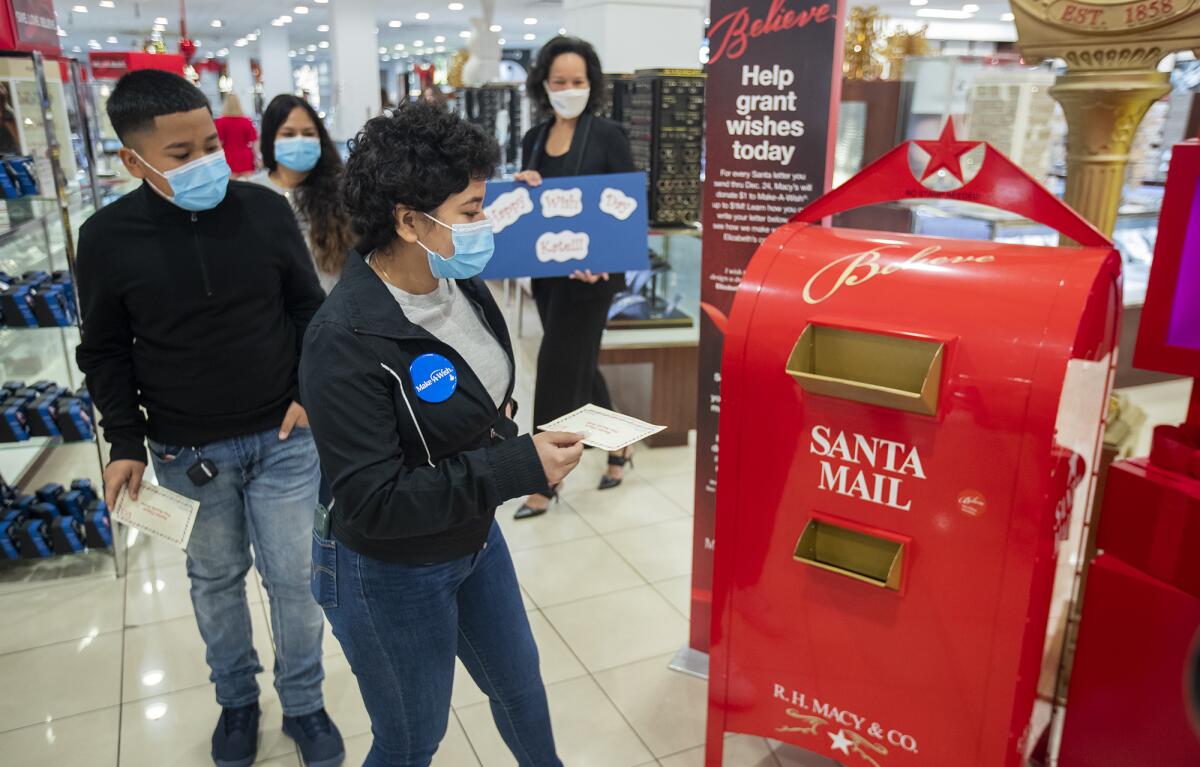 Kate Guerrero and her brother, Emilio, 11, drop a note to Santa Claus inside Macy's at South Coast Plaza.