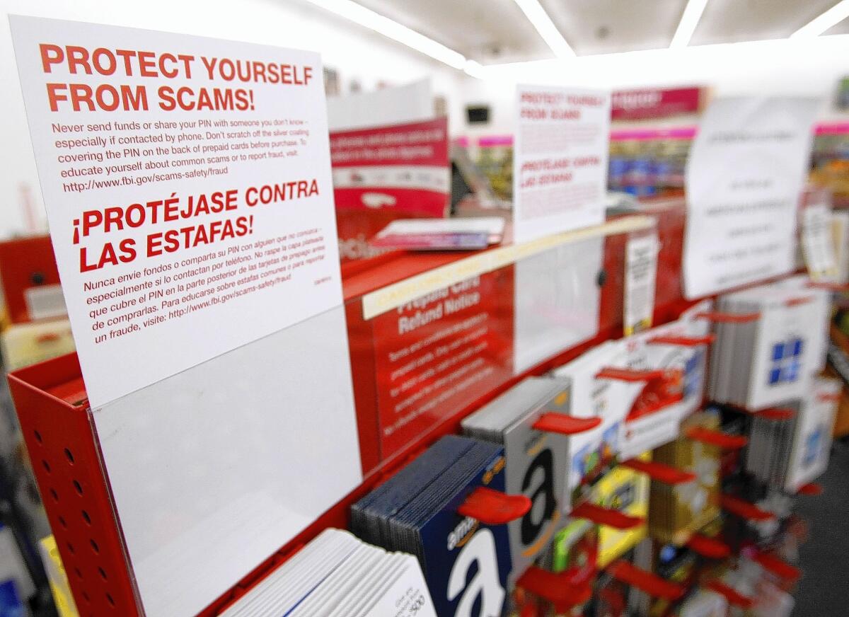 A sign in English and Spanish warns customers about phone scams at the CVS store on Broadway at Chevy Chase in Glendale on Friday, July 11, 2014.