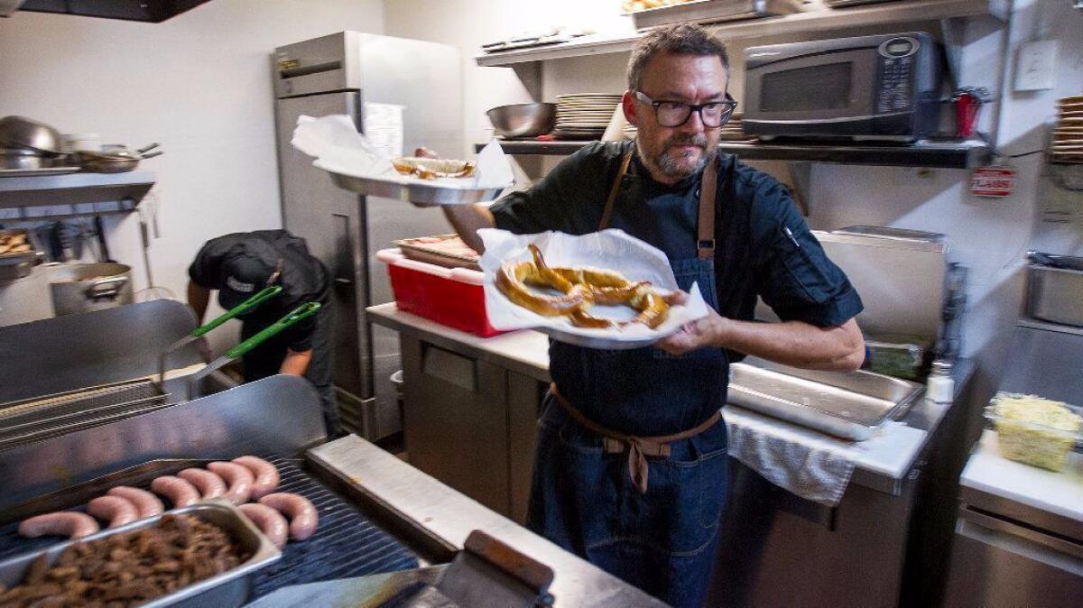 Thomas Curran, the co-owner of Taco Brat, prepares pretzels for guests during a tasting for his restaurant at the Harp Inn in Costa Mesa. (Scott Smeltzer / Daily Pilot)