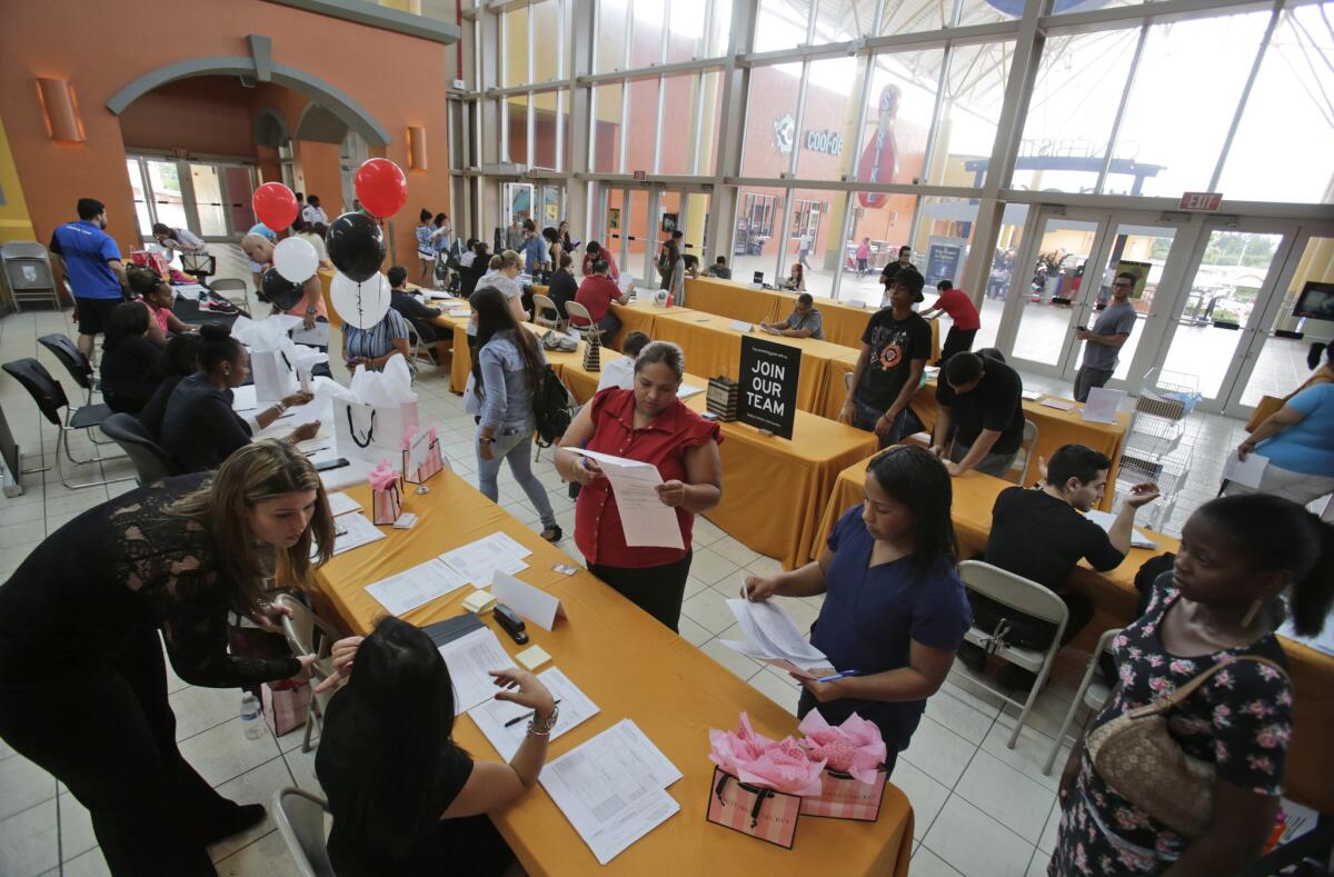 Job applicants fill out and turn in forms during a job fair at Dolphin Mall in Miami on Oct. 6.