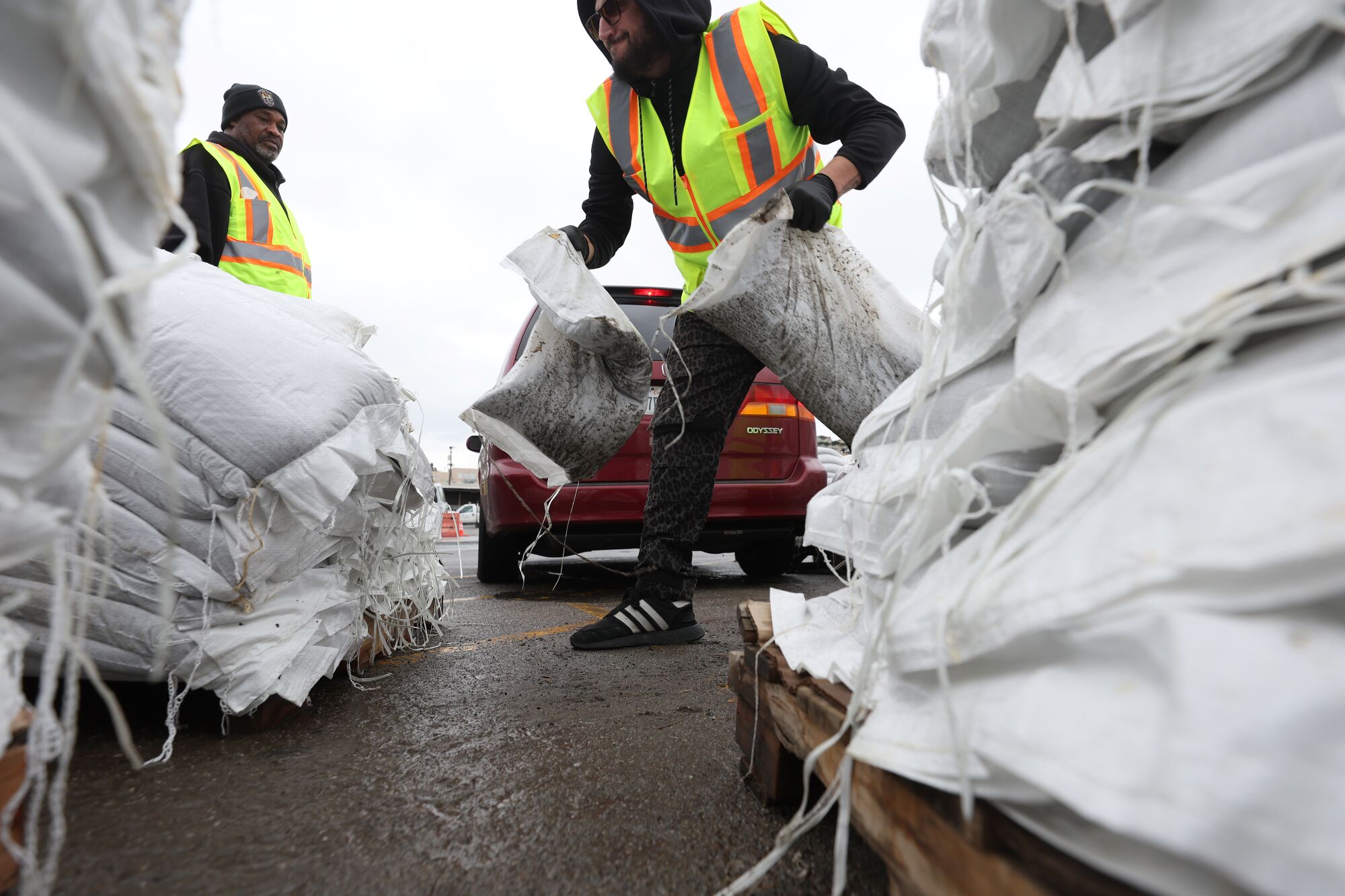 San Francisco city workers load sandbags into a car 