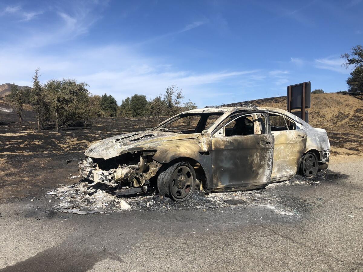 The burned-out shell of a security vehicle sits in the parking lot at Malibu Creek State Park.