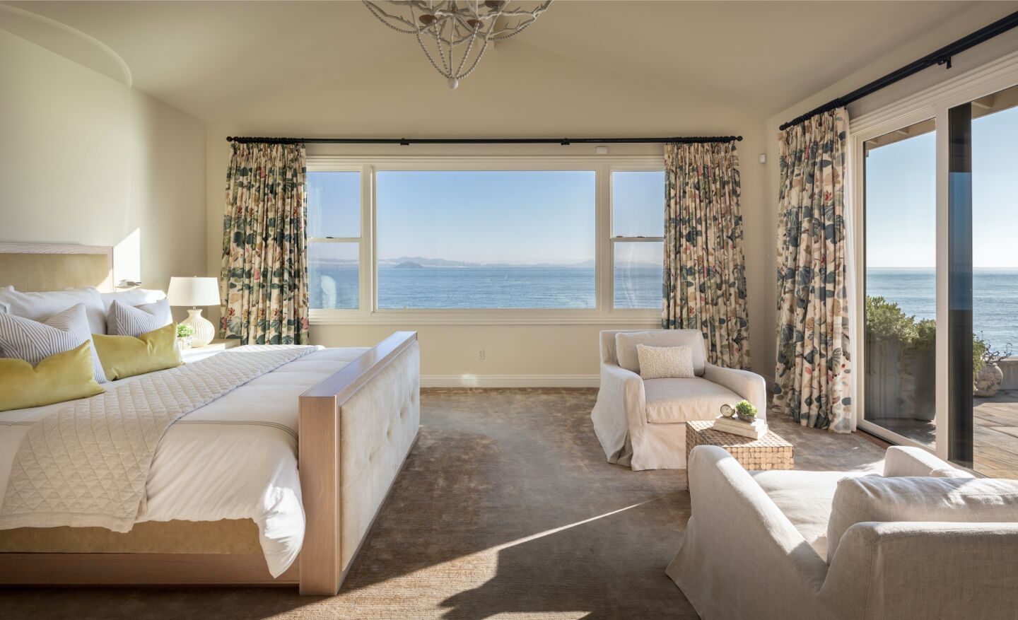 The furnished primary bedroom with windows overlooking the bay.