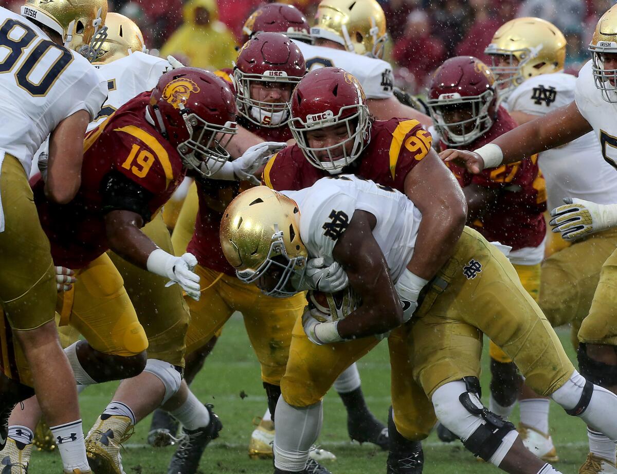 USC nose tackle Stevie Tu'ikolovatu wraps up Notre Dame running back Josh Adams in the second quarter.