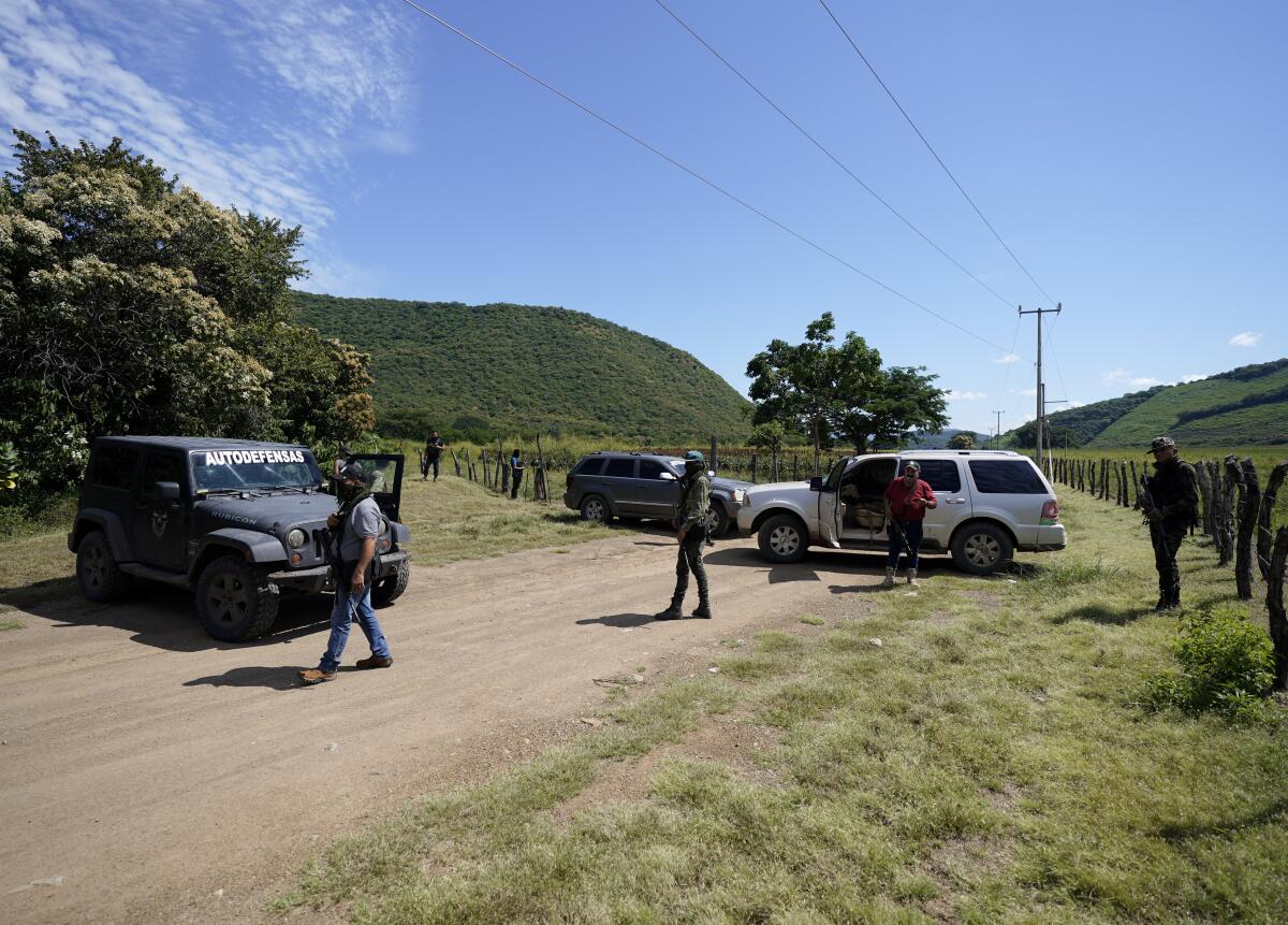 Individuos que dicen pertenecer a una fuerza de "autodefensa" vigilan una carretera de acceso a Taixtán, 