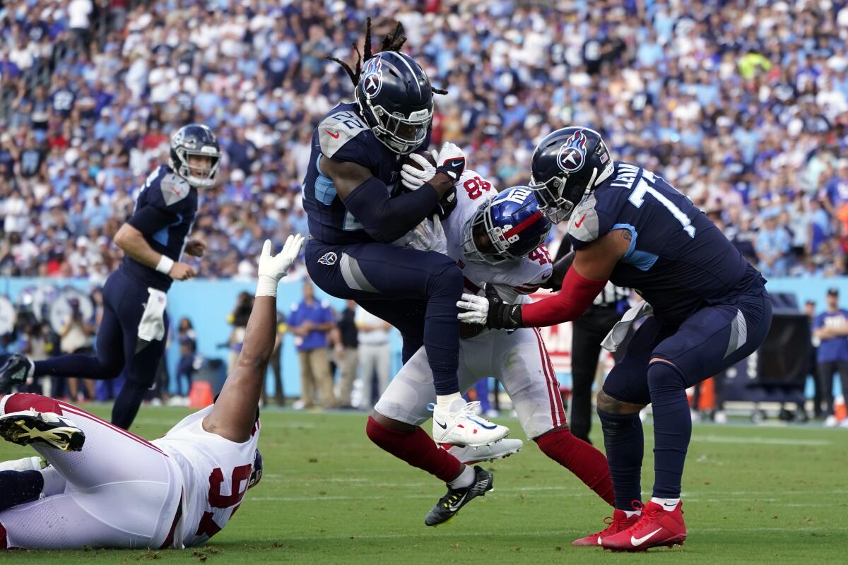 Tennessee Titans running back Derrick Henry (22) is stopped by New York Giants linebacker Tae Crowder (48) during the first half of an NFL football game Sunday, Sept. 11, 2022, in Nashville. (AP Photo/Mark Humphrey)