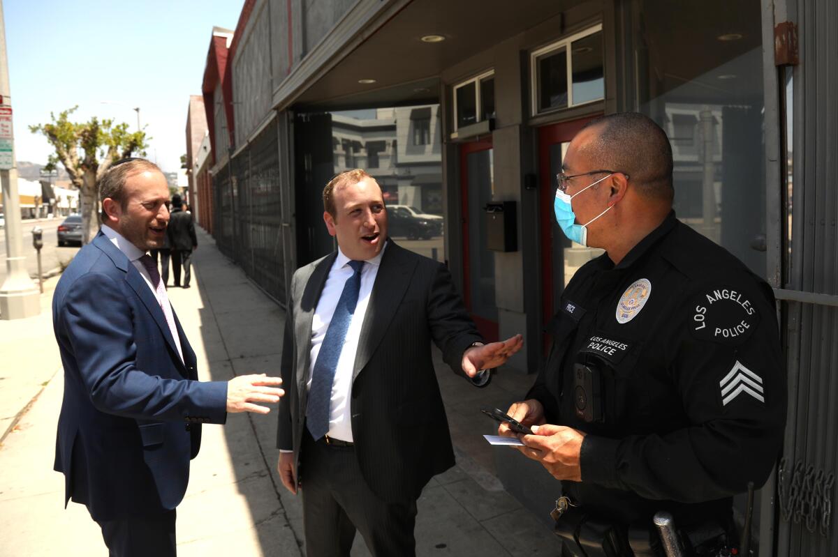 LAPD Sgt. Kenneth Price, right, talks with members of the Jewish community on La Brea Boulevard.