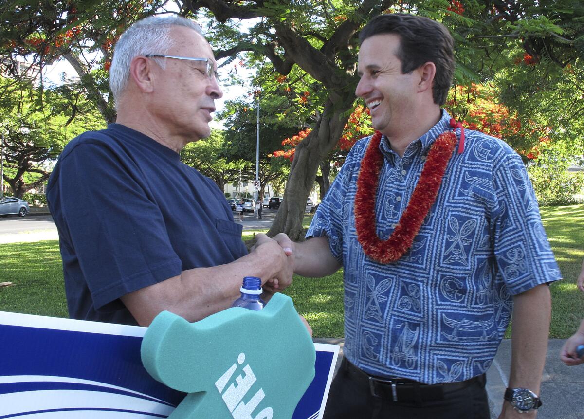 U.S. Sen. Brian Schatz, right, greets a supporter during a campaign event in Honolulu. Schatz faces a primary challenge from Rep. Colleen Hanabusa.