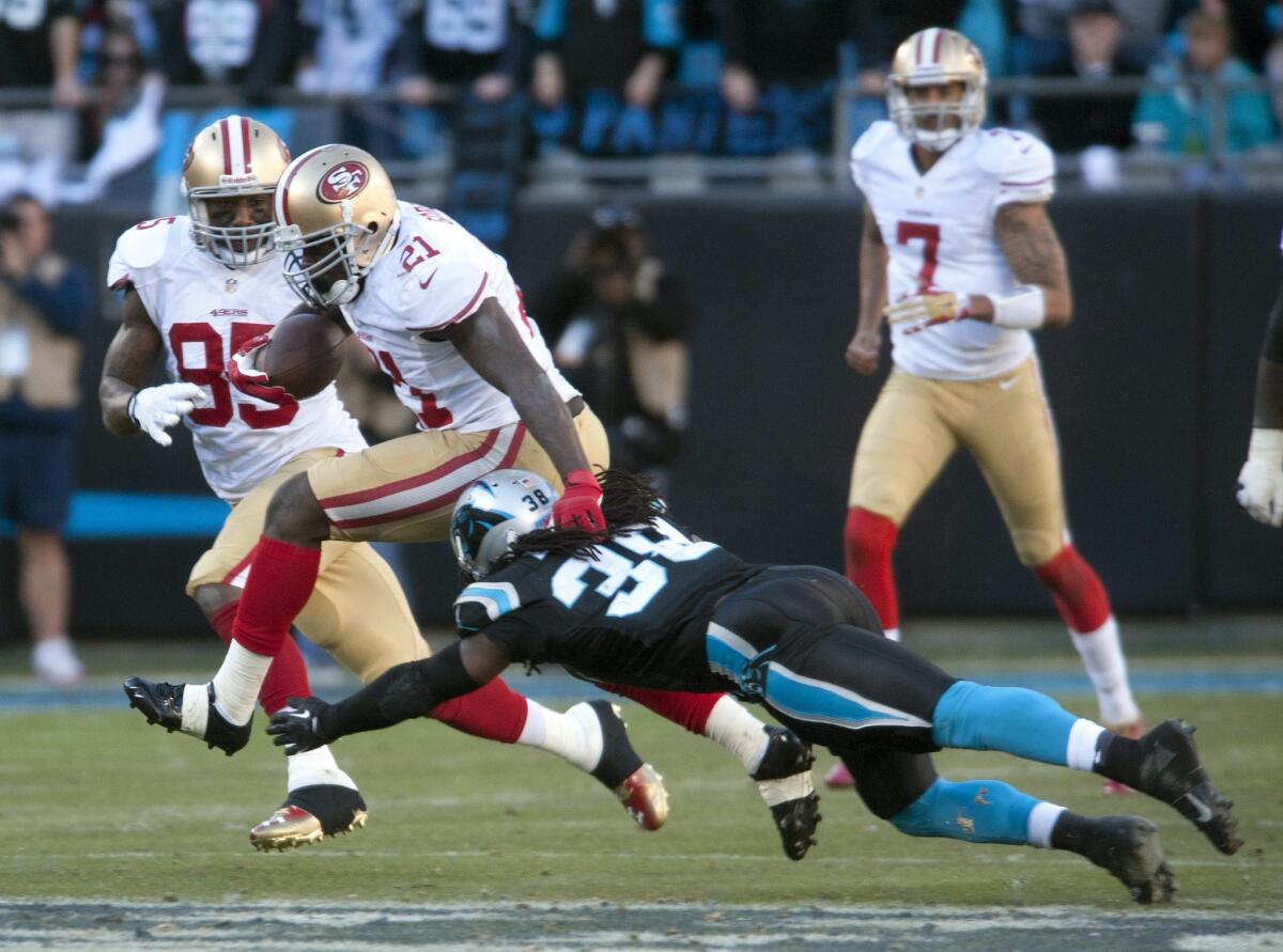 San Francisco 49ers' Frank Gore, second from left, breaks a tackle by Carolina Panthers' Robert Lester during a game in January. Former California Assemblyman Jeff Miller (R-Corona) has agreed to pay a $1,000 fine for improperly accepting two tickets to a San Francisco 49ers football game.