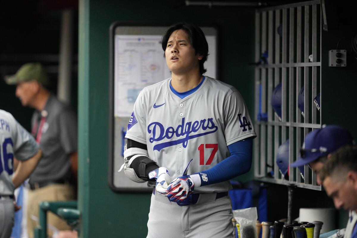 The Dodgers' Shohei Ohtani stands in the dugout after grounding out during the fourth inning against the Cincinnati Reds.