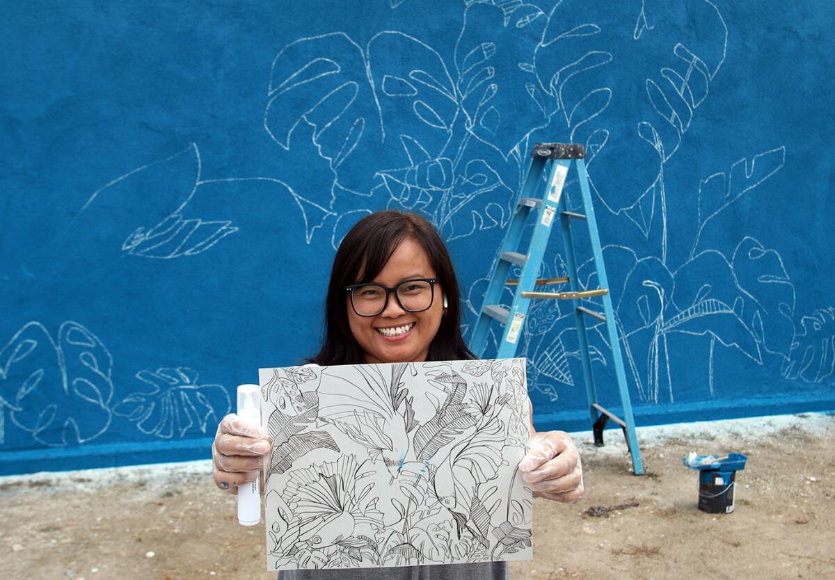 Sheryl Roth, an artist from Brea, shows her mural design at the Bishop Manor playground.