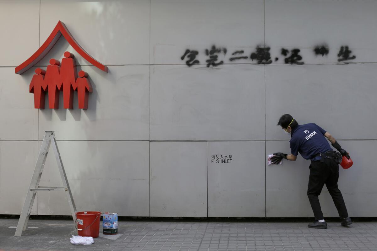 A worker cleans up a vandalized wall in Hong Kong on Monday.