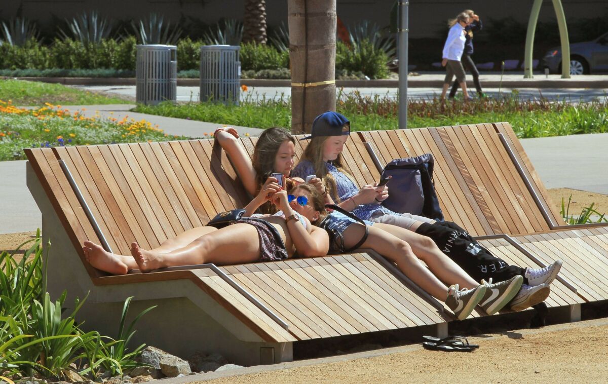 Three recently arrived visitors to San Diego from Germany relax on one of the comfortable lounges at new Lane Field Park in downtown San Diego. Left to right, there are Natalie Droste, Lisa Berns, and Nadine Schiller. — Charlie Neuman