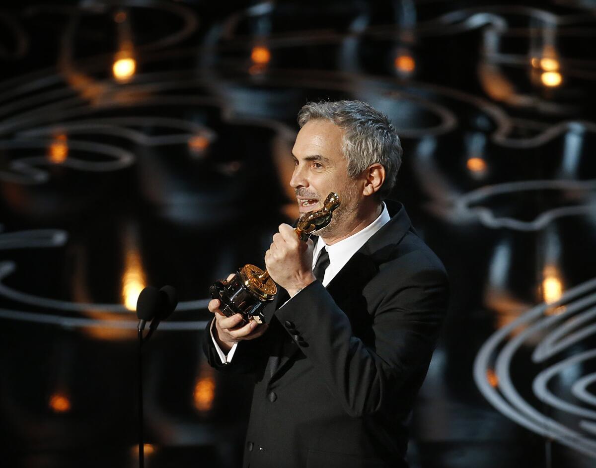 Alfonso Cuaron holds the directing Oscar he won for "Gravity" at the 86th Annual Academy Awards on March 2 in Hollywood.