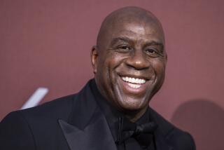 Magic Johnson poses for photographers upon arrival at the amfAR Cinema Against AIDS benefit