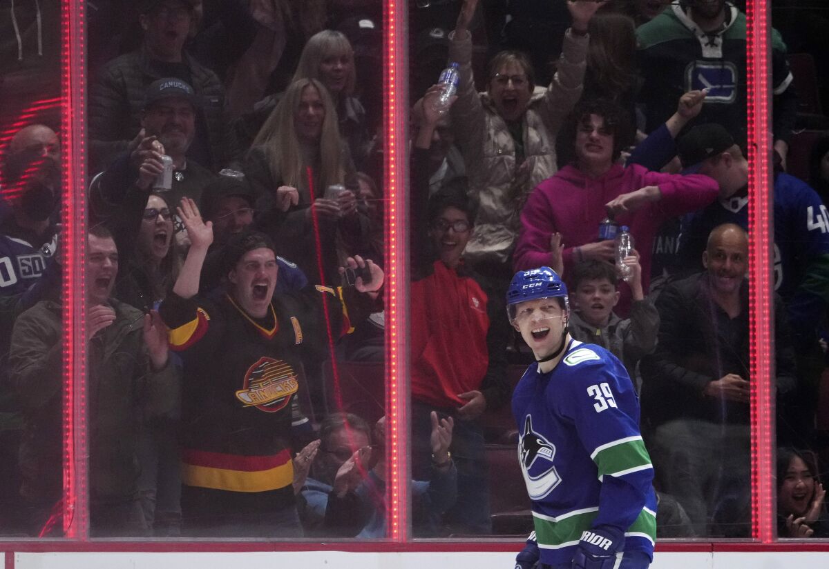 Vancouver Canucks' Alex Chiasson and fans celebrate his goal against the San Jose Sharks during the third period of an NHL hockey game Saturday, April 9, 2022, in Vancouver, British Columbia. (Darryl Dyck/The Canadian Press via AP)