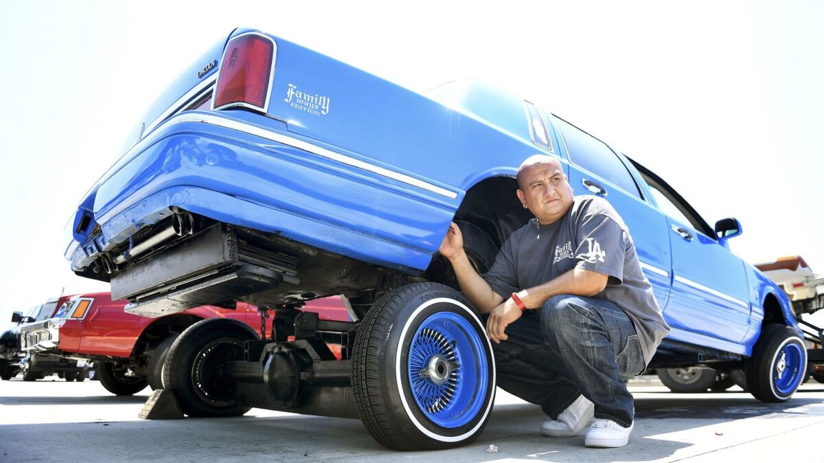 Eli Garcia with his car during the Torres Empire Los Angeles Super Show, a lowrider event and auto exhibition at the L.A. Convention Center.