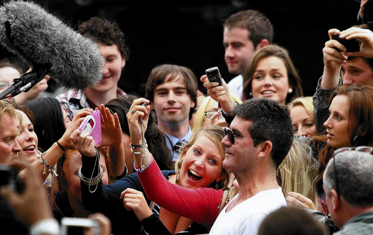 Simon Cowell has his picture taken with fans outside the Dublin Convention Centre in 2010.