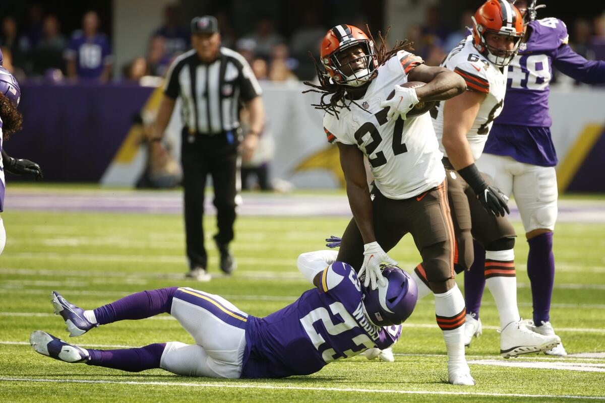 Cleveland Browns running back Kareem Hunt (27) runs from Minnesota Vikings free safety Xavier Woods (23) during the first half of an NFL football game, Sunday, Oct. 3, 2021, in Minneapolis. (AP Photo/Bruce Kluckhohn)
