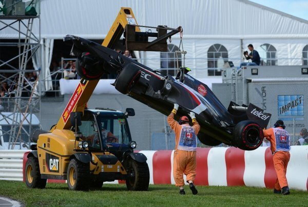 A crane lifts Esteban Gutierrez's car at the Canadian Grand Prix. A race-track worker was killed after he slipped and was run over by the crane.