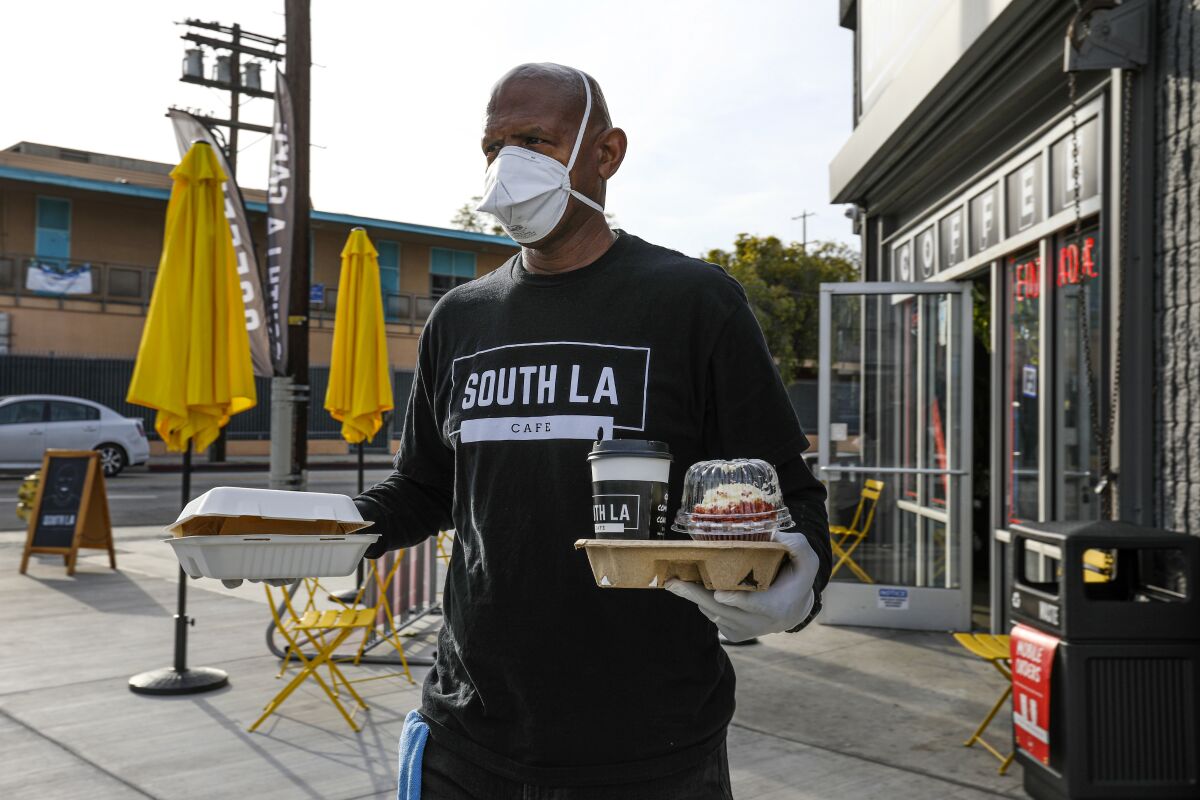 Joe Ward-Wallace delivers a takeout order at South LA Cafe on March 28.