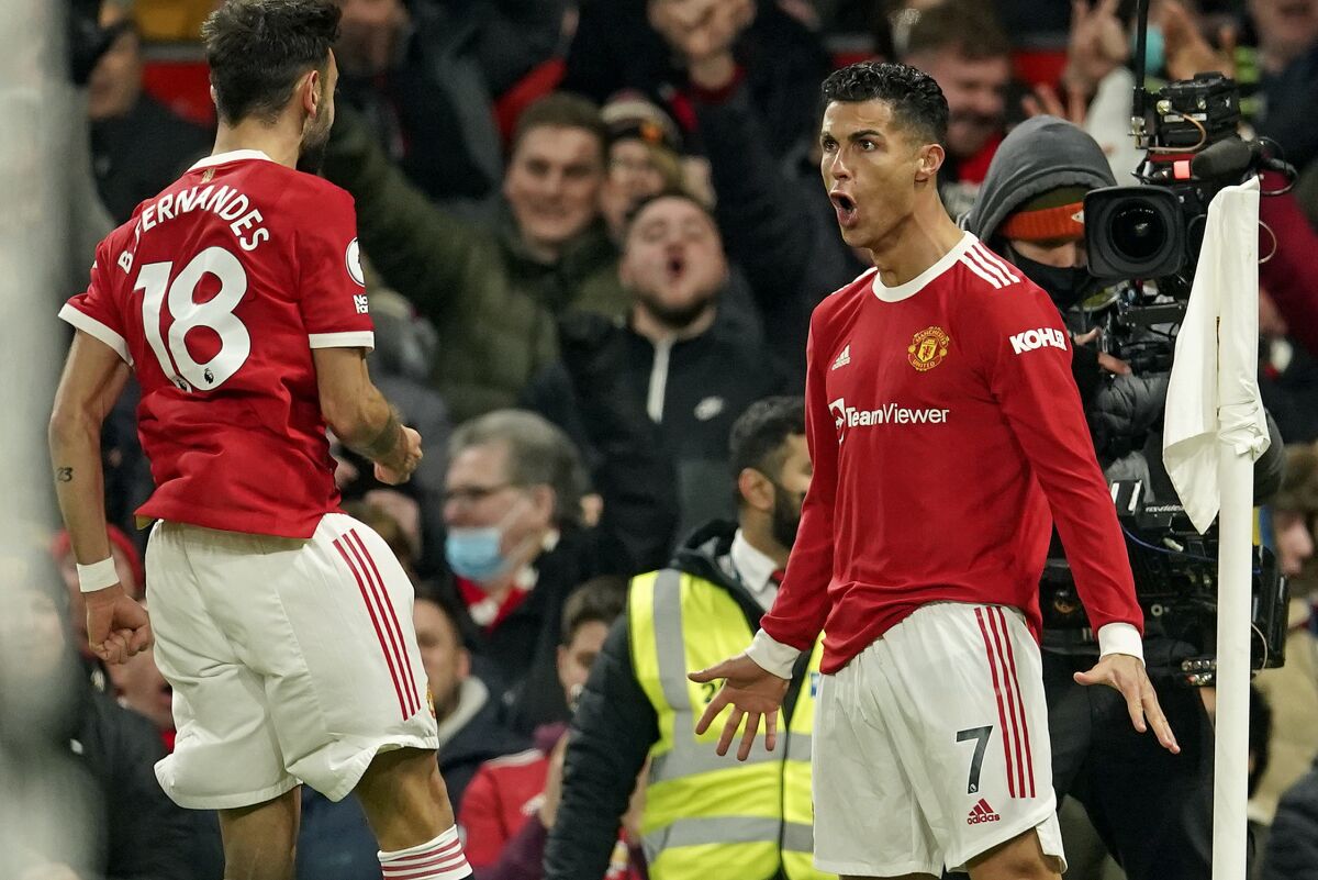 Manchester United's Cristiano Ronaldo, right, celebrates with Manchester United's Bruno Fernandes after scoring his side's second goal during the English Premier League soccer match between Manchester United and Arsenal at Old Trafford stadium in Manchester, England, Thursday, Dec. 2, 2021. (AP Photo/Dave Thompson)