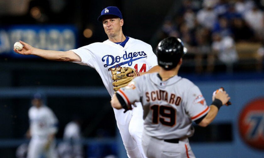 Dodgers second baseman Mark Ellis turns a double play in front of the Giants' Marco Scutaro during a game this summer.
