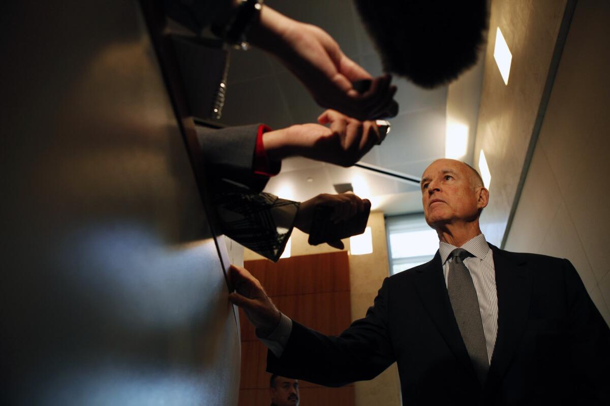 Gov. Jerry Brown talks with reporters after attending a meeting of the Cal State Board of Trustees in November.